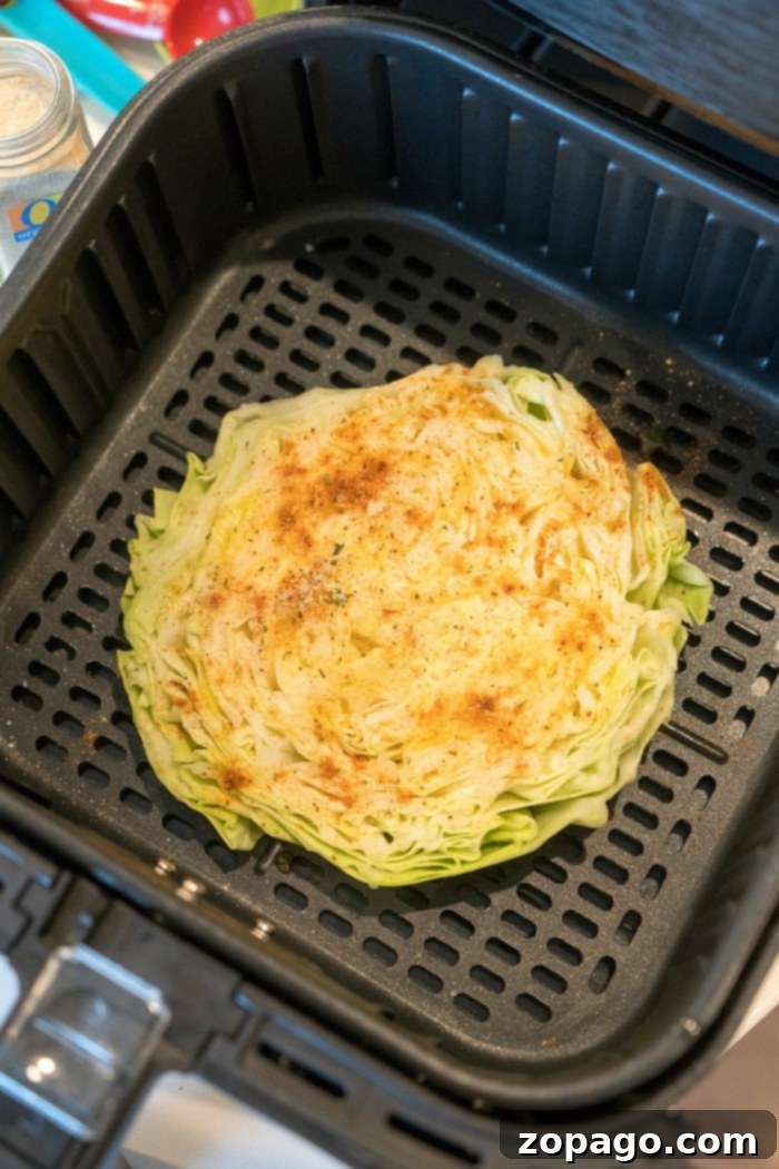 Air fryer cabbage steaks or quarters come out tender yet crispy on the edges with LOTS of flavor. If you love this vegetable, this is a new way to try it. #airfryer #airfryerrecipes #airfryercabbage #ninjafoodi #cabbage #cabbagesteaks Cabbage slices in an air fryer basket, perfectly cooked