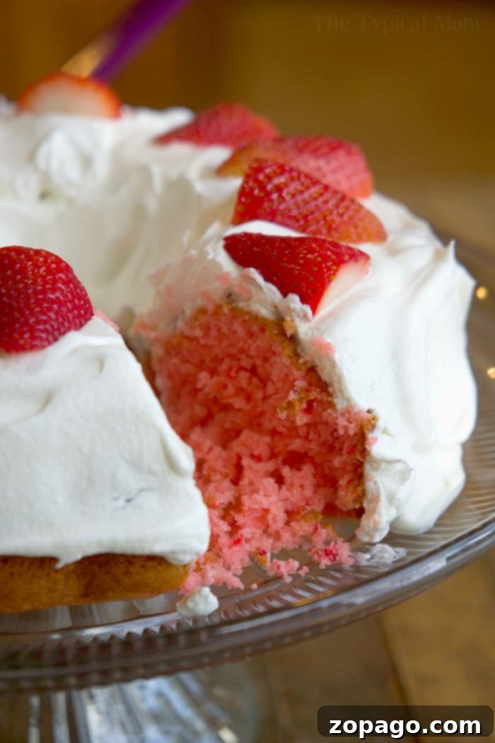 5-Ingredient Meals 10 Moist and flavorful 2-ingredient strawberry cake slice with a vibrant pink color, garnished with whipped cream and fresh strawberries.