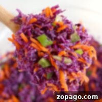 Vibrant Red Cabbage Slaw 6 A spoonful of vibrant red cabbage coleslaw with shredded purple cabbage, carrots, and green peppers.