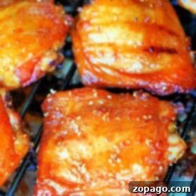 Close-up of Traeger smoked chicken thighs with a shiny, golden-brown glaze and distinct grill marks.