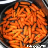 Baby carrots are perfectly seasoned and transformed into crispy tenderness as air fryer carrots when cooked in an air fryer basket.