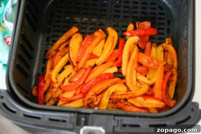 Air-Fried Bell Peppers: Quick, Easy, and Flavorful 8 Perfectly cooked air fryer bell peppers and onions in a Ninja Foodi basket, ready to be served.