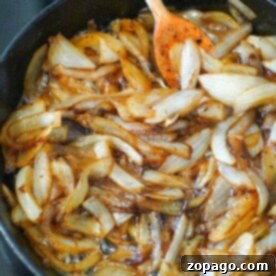 Caramelized onions with brown sugar on stove simmer nicely in the skillet, stirred gently with a wooden spoon.