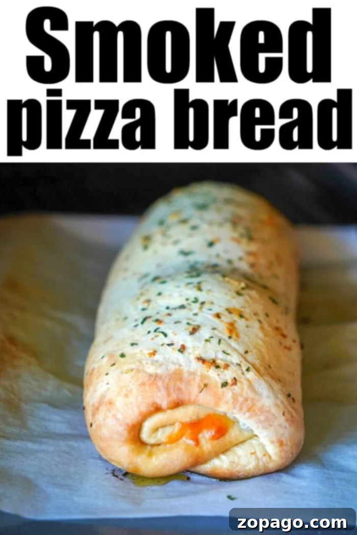 Pizza Swirls 9 Best Traeger pizza recipe - A whole, golden brown smoked pizza roll-up on a wooden board, ready to be sliced.