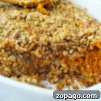 Baked sweet pumpkin crisp casserole with oat crumble topping in a white dish, reminiscent of a pumpkin crisp without cake mix.