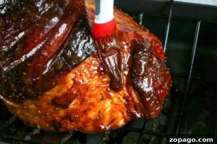 Sweet Bourbon Glazed Ham 5 Oven-baked ham with a caramelized honey glaze, being removed from the oven.