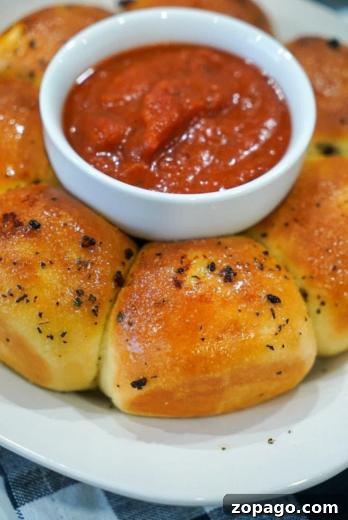 Crispy Air Fryer Frozen Rolls 2 Golden brown garlic bread rolls, fresh from the air fryer, garnished with herbs.