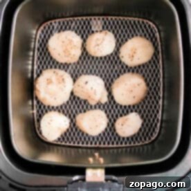 Golden Air Fryer Scallops 7 Air fryer scallops are seasoned with pepper and arranged in a single layer inside the air fryer basket for perfect, tender results.