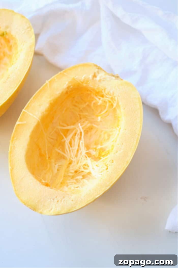 Easy Air Fryer Spaghetti Squash 3 Fresh spaghetti squash cut into two halves, with seeds removed, showing its readiness for air frying.