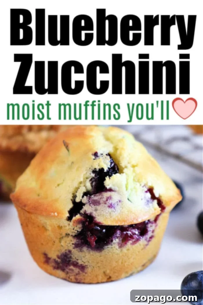 Heavenly Zucchini Blueberry Muffins 11 Two perfectly baked Zucchini Blueberry Muffins on a wooden cutting board, with one muffin cut in half to show its moist interior and visible blueberries and zucchini.