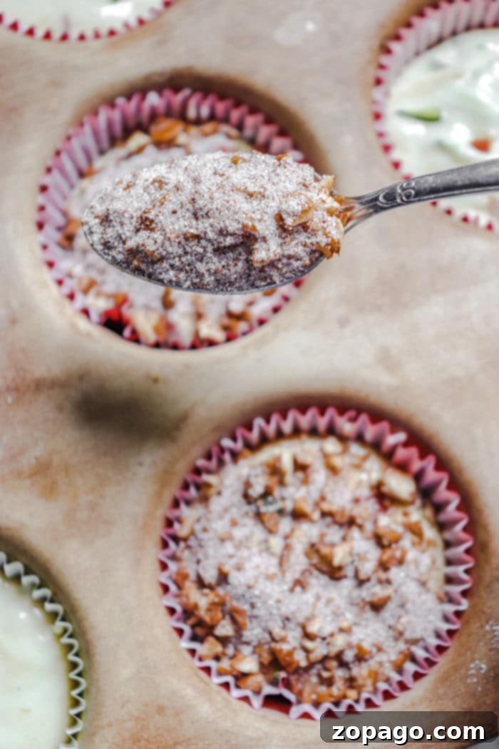 Orchard and Garden Muffins 7 Close-up of a muffin with a golden brown crumble topping, highlighting texture.