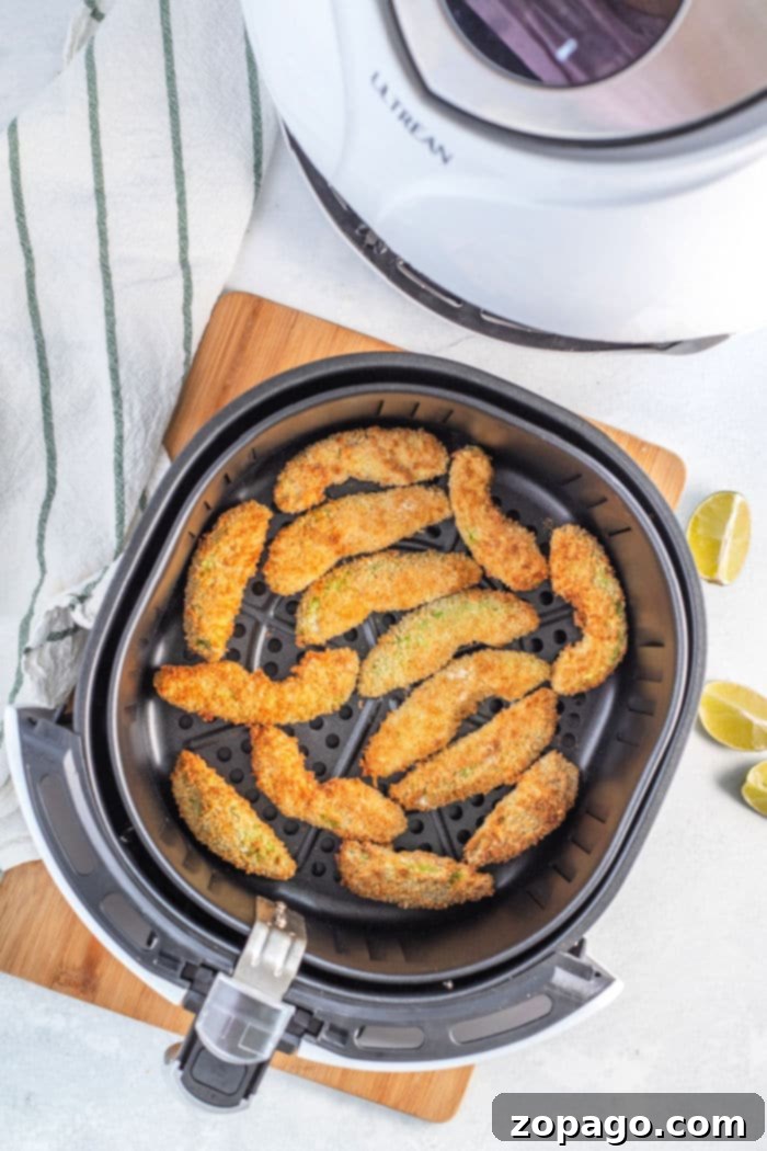 Close-up view of air fryer avocado fries showing their crisp texture and vibrant green avocado interior.