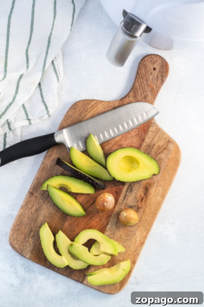 Perfectly sliced avocado halves ready for breading and air frying.
