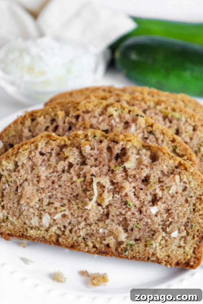 Tropical Zucchini Coconut Loaf 9 Full loaf of Coconut Zucchini Bread on a white plate, garnished and ready to be served