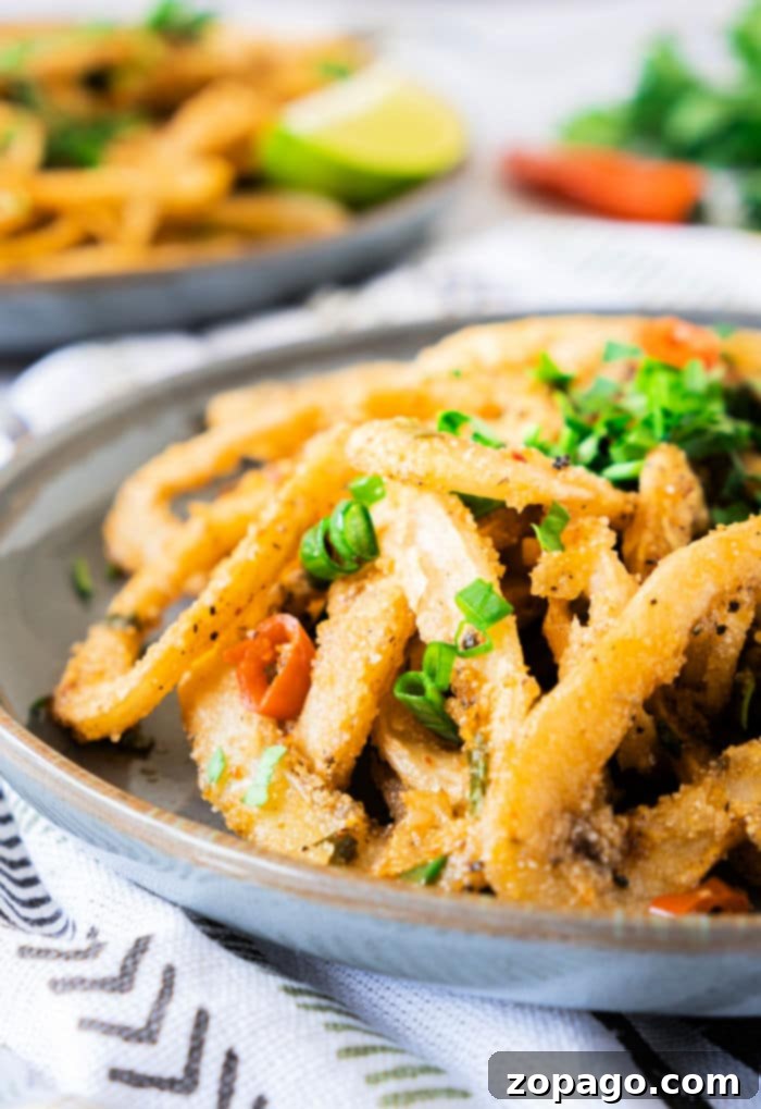Mastering Crispy Calamari at Home 2 How to Cook Calamari: A plate of perfectly golden-brown, crispy fried calamari rings, garnished with fresh parsley and lemon wedges, ready to be served as an irresistible appetizer.