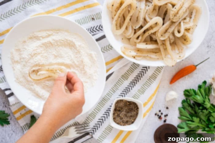 Mastering Crispy Calamari at Home 4 A serving of crispy fried calamari, garnished with fresh herbs and lemon wedges, reminiscent of the popular Olive Garden appetizer, promising a delightful culinary experience.