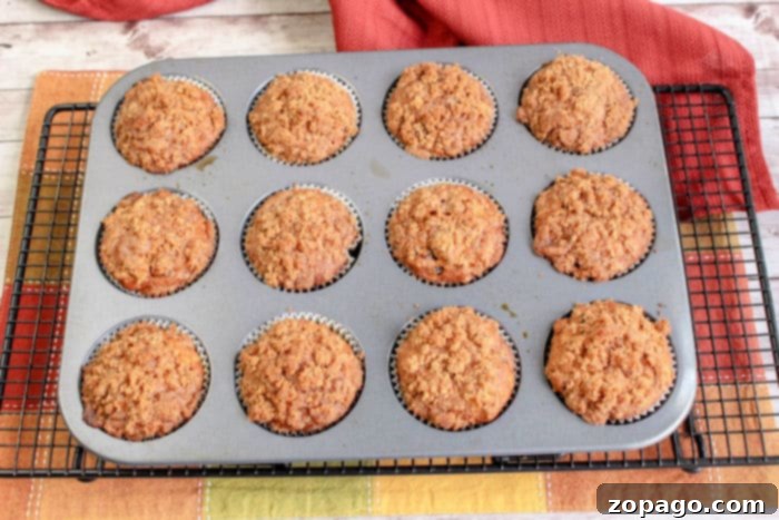 Spiced Pumpkin Streusel Muffins 7 A perfectly baked pumpkin muffin with a generous streusel topping, showcasing its golden crust and moist interior, ready to be eaten.