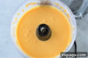 Make the Best Velveeta Cheese Sauce 6 Dry milk powder and gelatin being pulsed together in a food processor, a crucial step for smooth Velveeta cheese sauce.