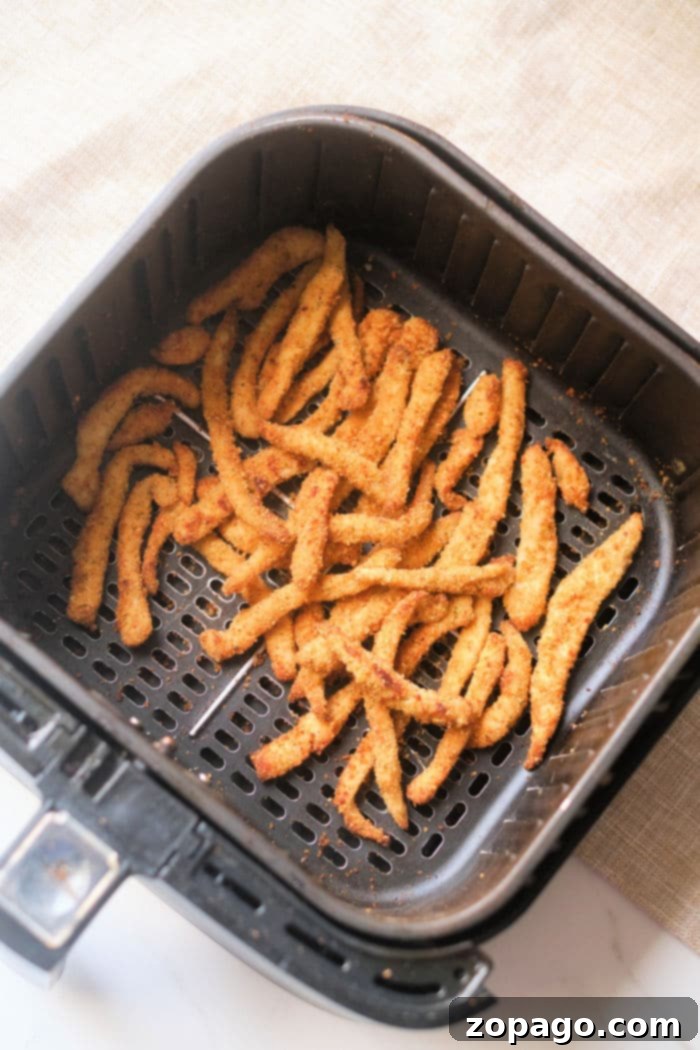 Crispy Air Fryer Chicken Fries 8 A plate of homemade air fryer chicken strips, golden brown and ready to eat.