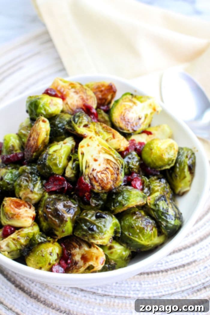Crispy Brussels with Sweet Balsamic Drizzle 2 Perfectly oven roasted Brussels sprouts with a glossy balsamic glaze, garnished with fresh herbs, in a rustic bowl.