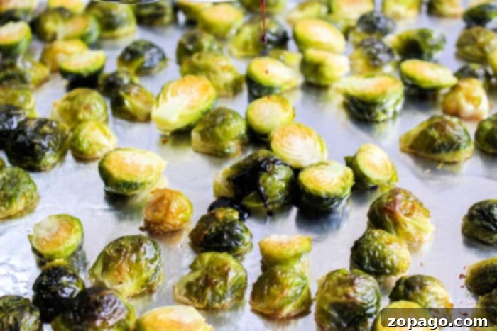 Crispy Brussels with Sweet Balsamic Drizzle 4 A close-up shot of perfectly roasted Brussels sprouts on a baking sheet, showing their caramelized edges.