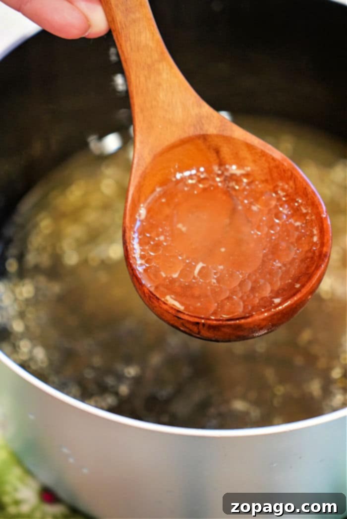 Effortless Instant Pot Bone Broth 2 Rich beef stock in an Instant Pot, surrounded by vegetables