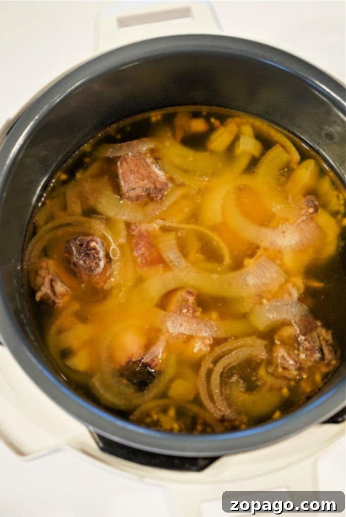 Effortless Instant Pot Bone Broth 4 Homemade beef stock simmering in a pressure cooker