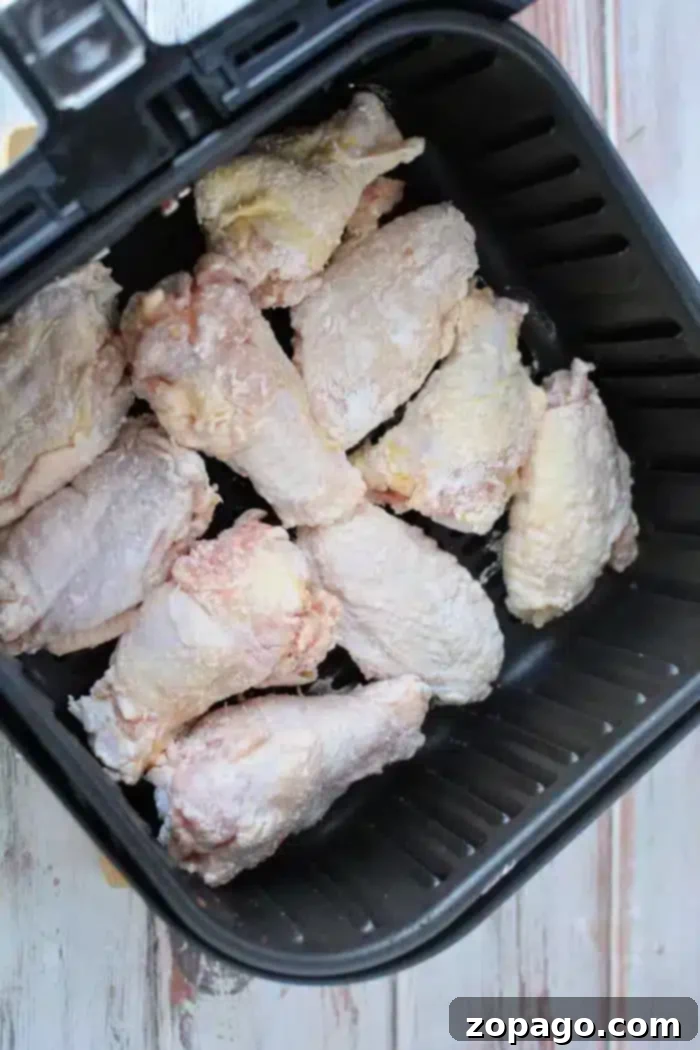 Crispy Air Fryer Chicken Wings with Baking Powder 6 Close-up of raw chicken wings, perfectly dusted with baking powder, arranged neatly in a black air fryer basket, ready for cooking to crispy perfection.