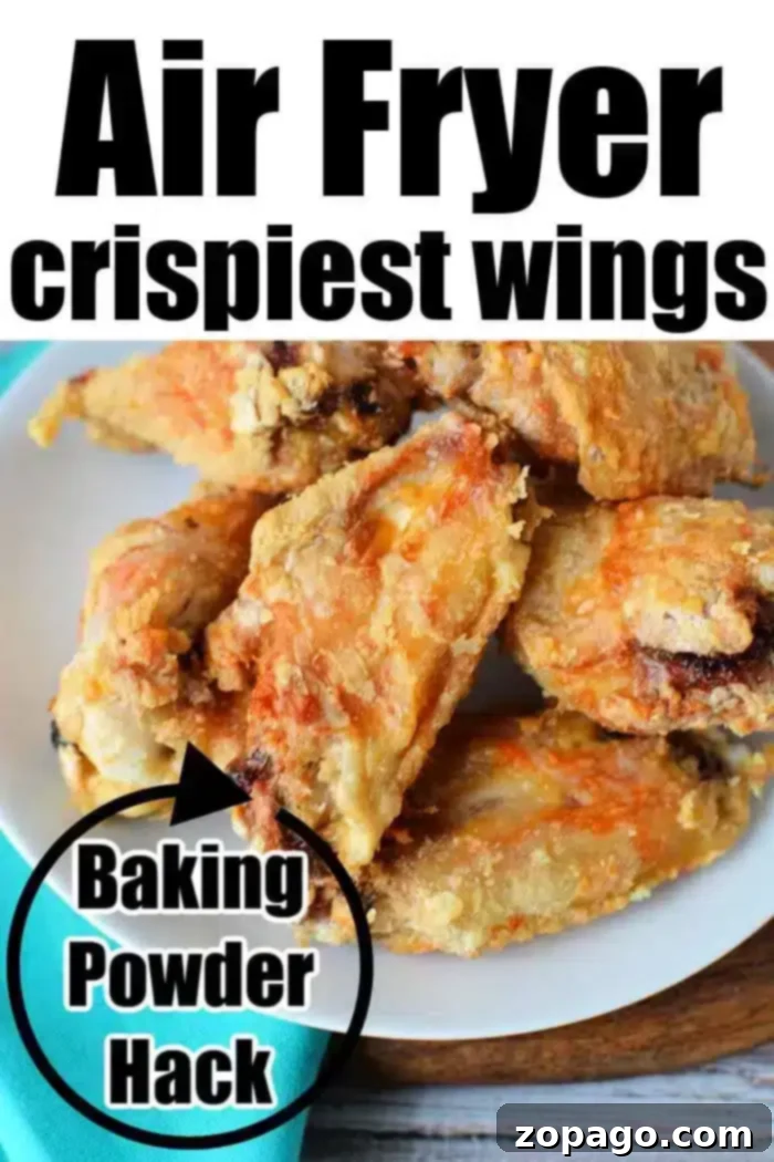 Crispy Air Fryer Chicken Wings with Baking Powder 8 A white plate filled with incredibly crispy Air Fryer Chicken Wings rests on a wooden surface beside a turquoise napkin. The image highlights the "Air Fryer Crispiest Wings" and the "Baking Powder Hack."