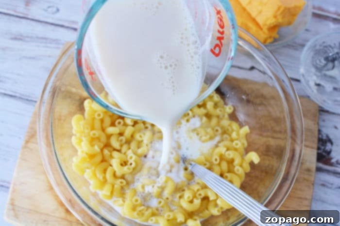 Mac 'n' Cheese in Minutes 4 How to Make Macaroni and Cheese in the Microwave - A microwave-safe bowl with macaroni and water, covered with plastic wrap, ready for cooking.