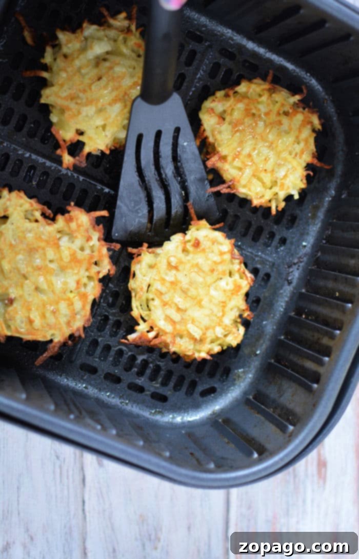 Golden Crispy Air Fryer Latkes 5 Air fryer basket filled with latkes cooking to a golden brown