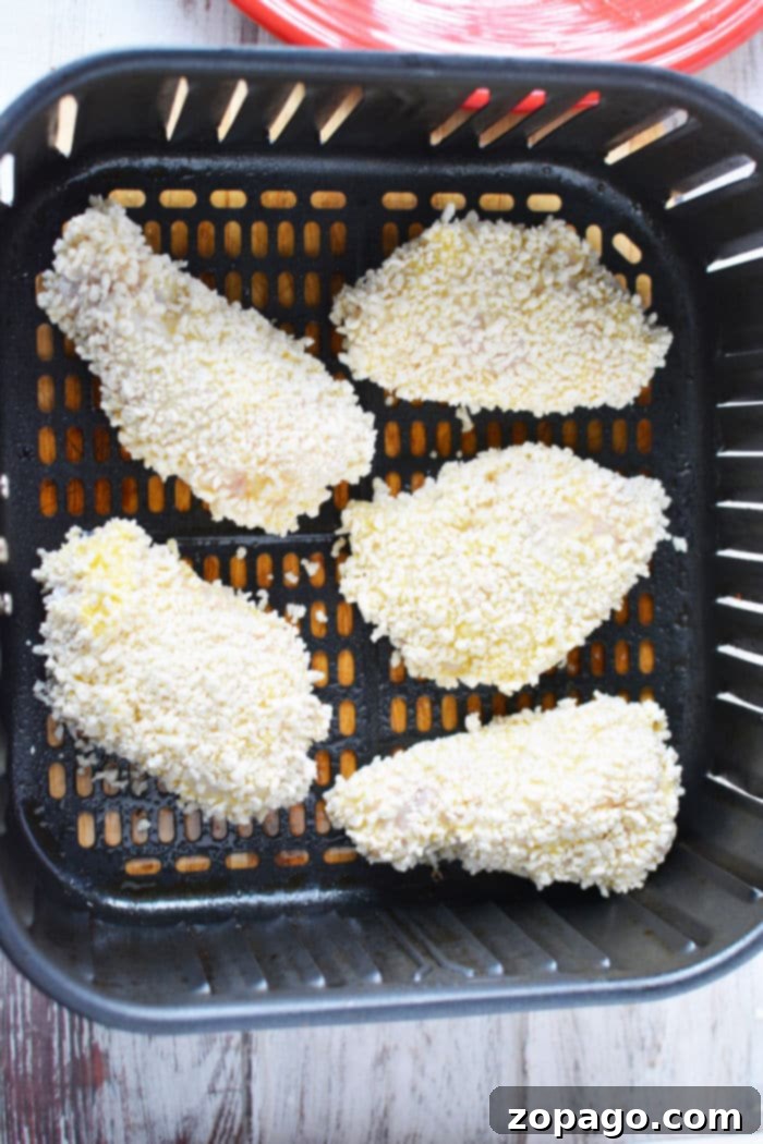 Crispy Gluten-Free Air Fryer Chicken Wings 8 A bowl of crispy Panko chicken wings, glistening and ready to be enjoyed, with a side of dipping sauce.