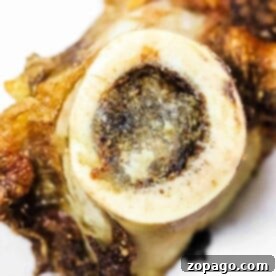 Unlocking the Delights of Bone Marrow 8 Close-up of a cooked bone with visible marrow, resting on a white surface, showcasing how to cook bone marrow to perfection.