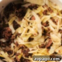 A bowl featuring a delightful sauerkraut recipe with meat includes cooked ground meat and sliced cabbage, lightly browned and perfectly mixed together.