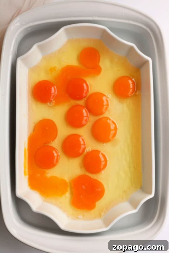 Effortless Peel-Free Hard-Boiled Eggs 3 A white rectangular dish displays raw egg yolks and whites, showcasing an inviting simplicity reminiscent of no peel hard boiled eggs, ready for the oven.