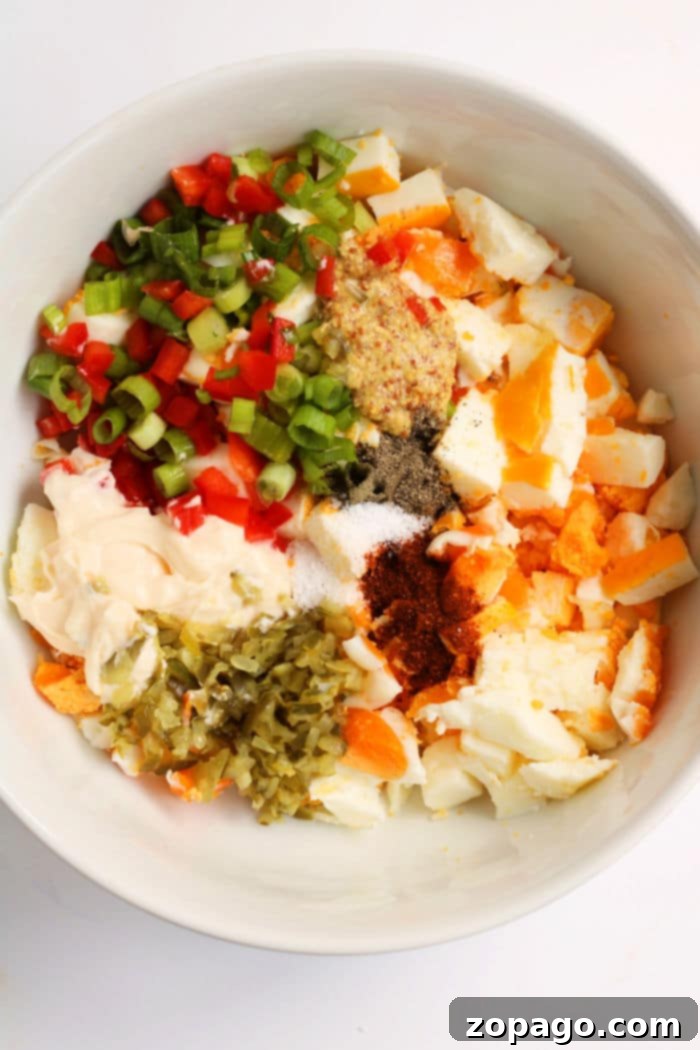 Effortless Peel-Free Hard-Boiled Eggs 7 Bowl of chopped no peel hard boiled eggs, peppers, green onions, mayonnaise, mustard, and spices, ready to be mixed into a delicious salad.