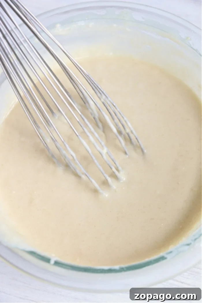 Oven-Baked Pancakes 8 Smooth pancake batter in a clear glass bowl, ready for cooking.