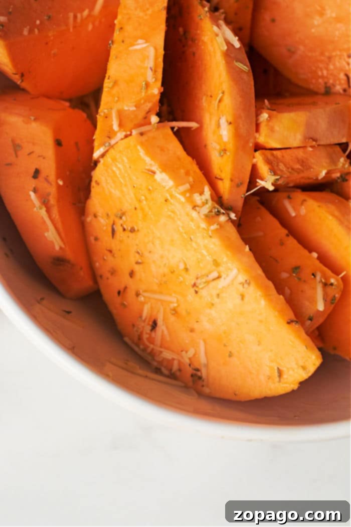 Ultimate Crispy Air Fryer Sweet Potato Wedges 4 Stack of crispy air fryer sweet potato wedges with a sprinkle of herbs.
