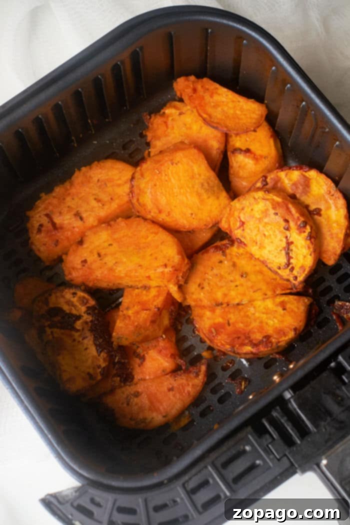 Ultimate Crispy Air Fryer Sweet Potato Wedges 6 A basket full of golden Air Fryer Sweet Potato Wedges.
