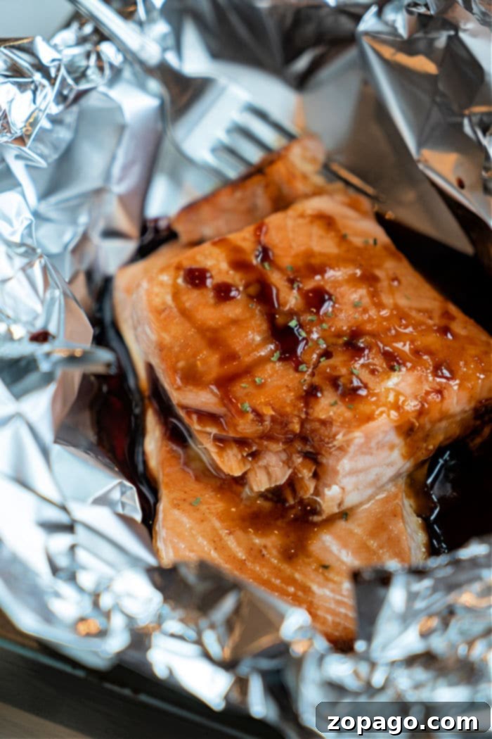 Sticky Teriyaki Salmon 7 A delicious cooked teriyaki salmon fillet, glazed and ready to be served, garnished with fresh herbs and a drizzle of sauce.