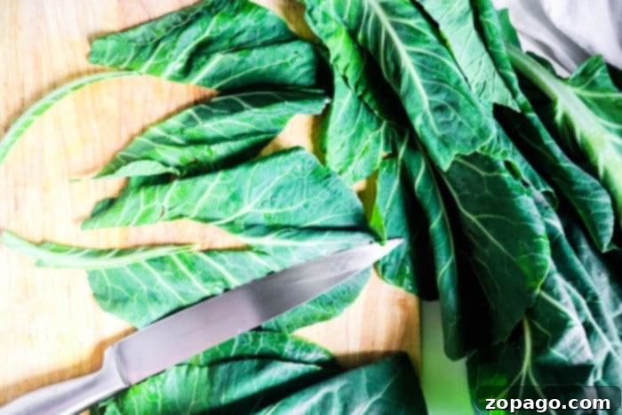 A close-up view of fresh collard greens on a cutting board, ready for preparation.