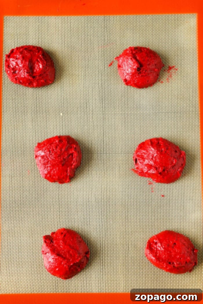 Easy Cake Mix Whoopie Pies 6 A stack of perfectly baked red velvet whoopie pies, filled with creamy white frosting, displayed against a warm, inviting background. The image emphasizes their soft texture and delicious appeal.
