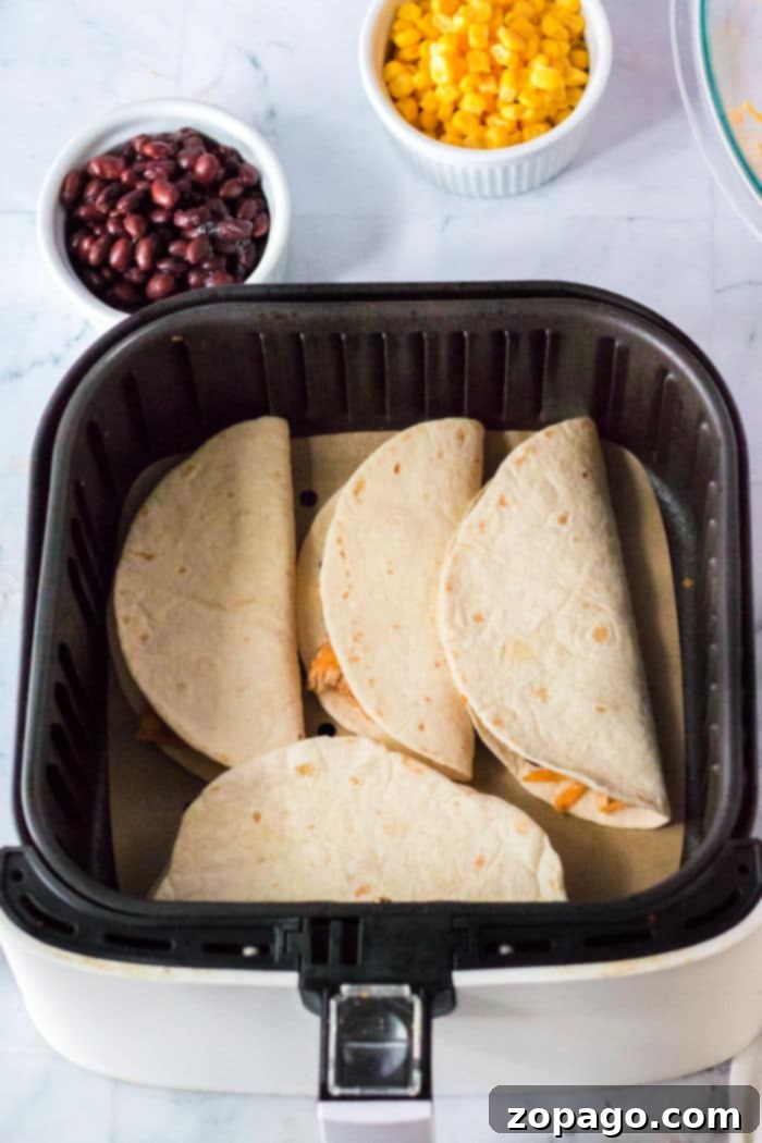Crispy Air Fryer Tacos 5 Ninja Foodi Tacos, showing two crispy tacos in an air fryer basket, ready to be served.
