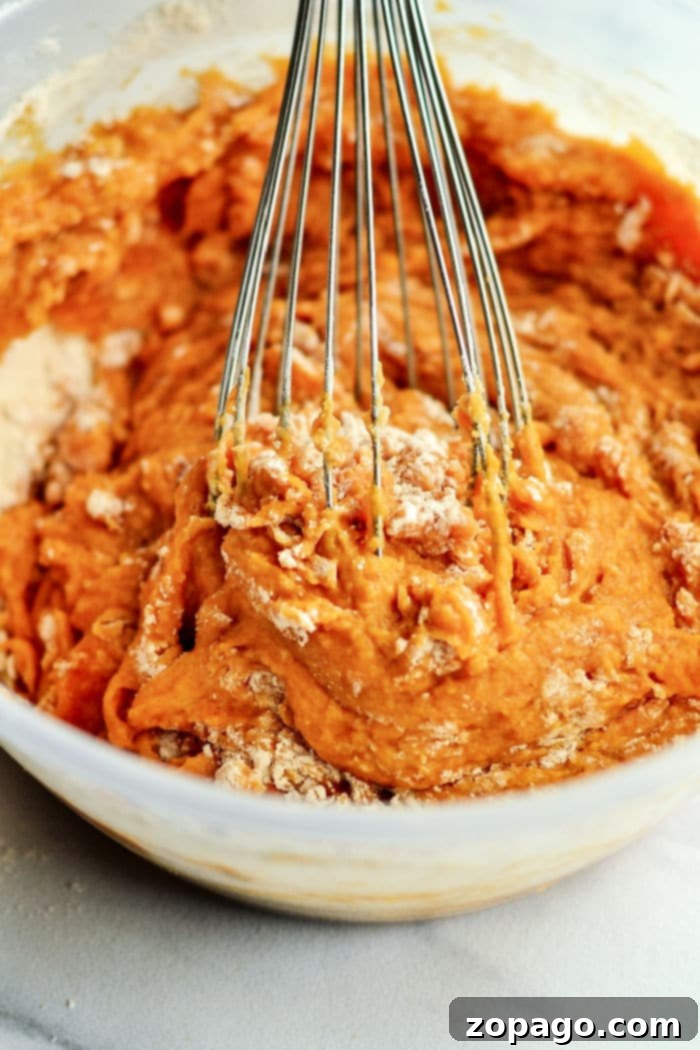 Cozy Autumn Pumpkin Muffins 3 Homemade pumpkin muffin batter in a mixing bowl, smooth and ready to scoop