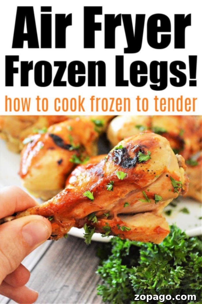 Perfectly cooked frozen chicken legs in an air fryer basket, showing crispy skin and golden-brown color.