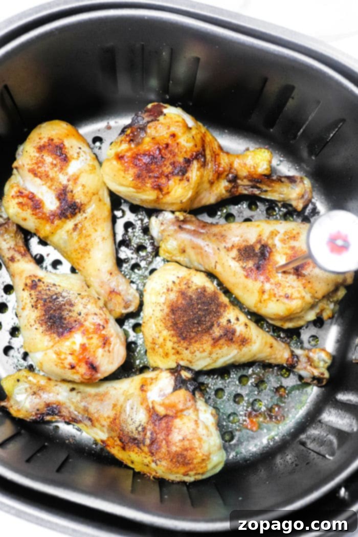 A basket full of golden-brown, crispy air-fried frozen chicken drumsticks, ready to be served.
