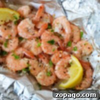 Grilling frozen shrimp seasoned with herbs and spices, garnished with lemon wedges, served elegantly on aluminum foil.