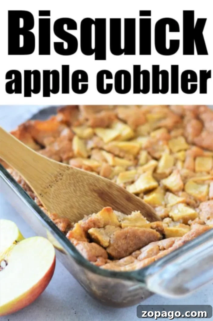 Easy Bisquick Apple Cobbler 8 A glass baking dish filled with apple cobbler. A wooden spoon is scooping up a portion. The top text reads "Apple Cobbler with Bisquick." Two apple slices are visible next to the dish on the left side of the image.