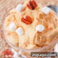 Spiced Pumpkin Cream Cheese Delight 4 Pumpkin cream cheese mousse topped with marshmallows and pecans in a glass dish.