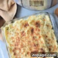 Creamy mashed potato casserole reminiscent of an Instant Pot Shepherd's Pie, served in a glass dish next to your trusty instant pot and a kitchen towel.